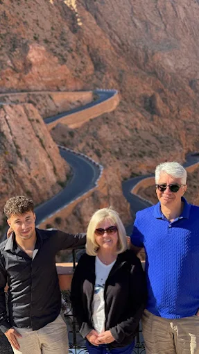 Trois voyageurs devant une route sinueuse dans des gorges rocheuses